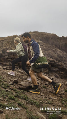 two people running up a rocky hill on a cloudy day with the caption be the goat