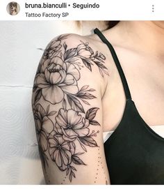 a woman's arm with flowers on it and the words tattoo factory in front of her