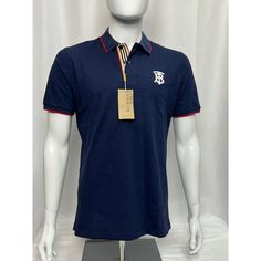 Burberry Icon Stripe Placket Cotton Piqu Polo Shirt A Classic Polo Shirt Style, Burberry Elevates This Short-Sleeved Piece With Signature Details. In A Navy Blue Colourway, It Is Embroidered With A Tb Monogram Motif, While The Icon Stripe Is Seen At The Placket. Highlights A Classic Polo Shirt In Airy Cotton Piqu, Updated With An Embroidered Monogram Motif, Tipped Collar And Our Icon Stripe At The Placket. Cotton 100% Designer Cotton Polo Shirt For Summer, Luxury Blue Cotton Tops, Luxury Blue Cotton Shirt, Designer Fitted Polo Shirt, Luxury Blue Shirt For Summer, Luxury Short Sleeve Top With Striped Collar, Designer Short Sleeve Tops With Placket, Luxury Navy Top For Workwear, Luxury Navy Tops For Work