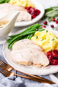 two white plates with turkey, mashed potatoes and cranberry sauce on them