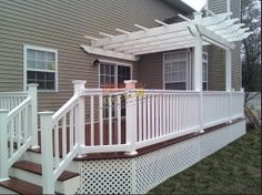 a house with a white pergolan on the front porch