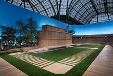 a large building with grass and benches in front of it