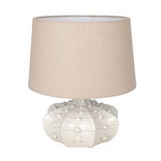 a white table lamp with a beige shade on the top and bottom part of it