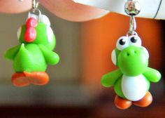 a pair of green and white toy animals hanging from earrings