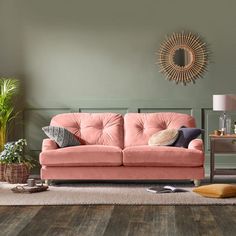 a living room scene with focus on the couch and rugs, potted plants