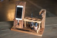 a cell phone is sitting on top of a wooden holder that holds pens and pencils