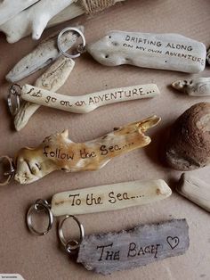 several key chains with writing on them sitting next to shells and sea urchins