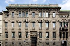 an old building with many windows and statues on the front