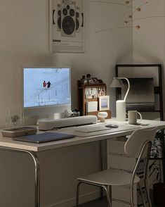 a desk with a computer monitor, keyboard and mouse next to a chair in front of it