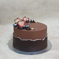 a chocolate cake with strawberries and blueberries on top