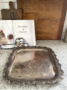 a metal tray sitting on top of a counter next to a book