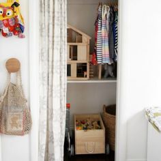 an open closet with clothes and toys in it