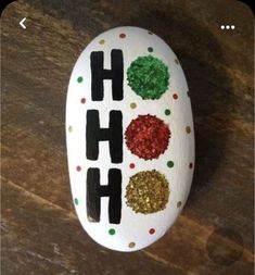 a painted rock with the words ho ho on it and some glitters in different colors