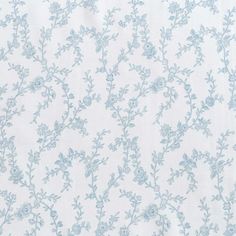 a white and blue wallpaper with small flowers on the top half of it,