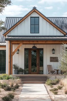 Modern farmhouse barndominium featuring sliding barn door, porch with rocking chairs, and neutral color palette Porch With Rocking Chairs, Modern Farmhouse Barndominium, Door Porch