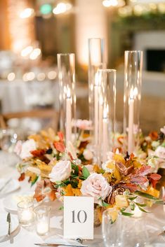 the table is set with flowers and candles for an elegant wedding reception or special event