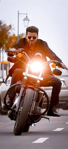 a man riding on the back of a motorcycle down a street