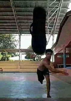 a shirtless man doing a handstand in an indoor area with no one on it