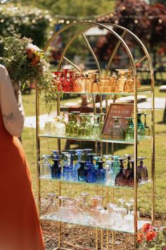 a display case with many bottles and glasses on it's sides in the grass