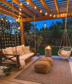 an outdoor living area with swing chairs and lights