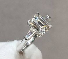 an engagement ring with three baguets on top