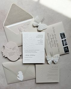 the wedding stationery is laid out on top of each other, including an envelope