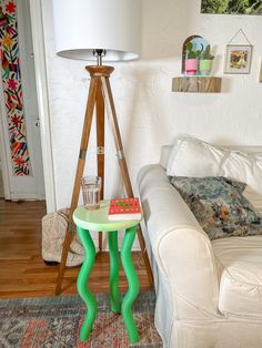 a living room with a white couch and green table