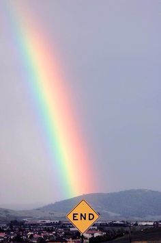 a rainbow appears in the sky over a rural area