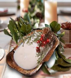 the table is set with candles, plates and napkins for christmas dinner guests to enjoy