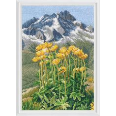 a cross stitch picture with yellow flowers in front of mountains