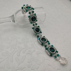 Handmade beaded bracelet featuring a gorgeous combination of sterling silver seed beads, green delica beads, emerald green bicones and Swarovski emerald crystal rivolis with a filigreed box closure. The bracelet is approximately 6.75 beaded inches long.  You'll love wearing this elegant beaded bracelet! Keep it for yourself or give someone a beautiful gift!  I can make almost any color combo  or make it specifically to your wrist size upon request.  Please contact me with desired colors and  wrist size and I will do the rest.  Ready to ship.  Design by Deb Roberti. Attention! Colors may look different depending on your monitor settings. Jewelry Care:  To keep the materials in your jewelry in good condition, do not wear while swimming, bathing, or heavily exercising. Avoid contact with abra Green Sterling Silver Beaded Bracelets, Beaded Emerald Jewelry Gift, Green Crystal Round Bracelet For Parties, Green Round Crystal Bracelet For Party, Green Sterling Silver Beaded Bracelet, Elegant Green Czech Glass Beads, Elegant Green Bracelets With Spacer Beads, Elegant Green Bracelet With Spacer Beads, Elegant Green Beaded Bracelets With Faceted Beads