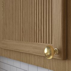 a close up of a wooden cabinet with white tile