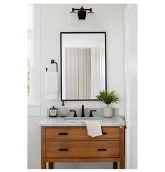 a bathroom sink with a mirror above it and a towel hanging on the wall next to it