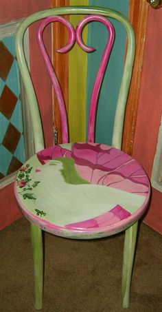 a pink and green chair sitting in front of a door