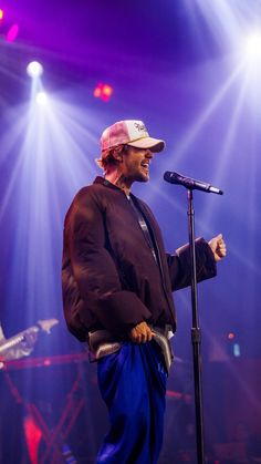 a man standing in front of a microphone on stage