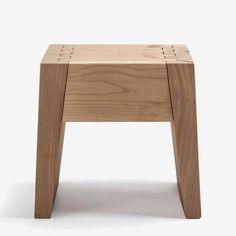 a small wooden stool sitting on top of a white floor