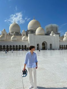 a man standing in front of a large building with domes on it's sides