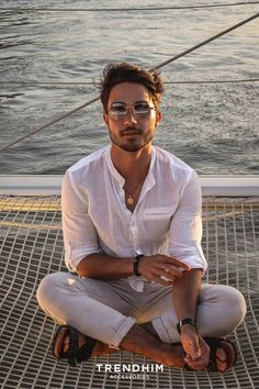 Man sitting on a boat net wearing a sunglasses with the dark shades. He has an old money vibe wearing a loosen white linen shirt with elegant pants. Outfit Old Money, Look Classy, Money Aesthetic, Old Money Aesthetic