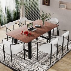 a dining room table with chairs and a laptop computer on top of it in front of a window