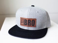 The perfect Big Bro / Lil Bro hats are here!  These trendy, Popular Snap Back Hats, are sure to please.  Features a Firm Rectangular Brim, Sturdy Crown. Light Grey Denim Fabric with Black Brim.  Made of 100% Polyester S I Z E --  INFANT (0-3 years)  KIDS (3-9 years) ADULT/YOUTH (9 and up) Check out our matching Newborn Baby Beanie --  https://thebugandbrim.etsy.com/listing/1567820628 Crown Light, Snap Back Hats, Lil Bro, Snap Back, Grey Denim, Snap Backs, Leather Patches, Baby Beanie, Big Brother