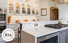 a kitchen with marble counter tops and stainless steel stove top ovens, built - in cabinets, and an island