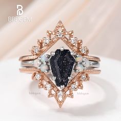 a ring with a black diamond surrounded by white and pink diamonds on top of it