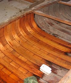 an old wooden boat laying on the ground in a room that is being renovated and remolded