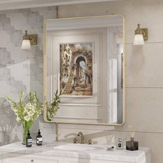 a bathroom with a sink, mirror and vase on the counter in front of it