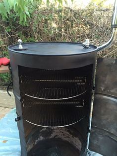 an outdoor charcoal grill is shown with the door open and it's cooking inside