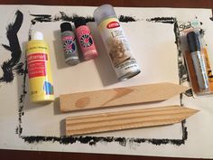 some crafting supplies are sitting on top of a piece of paper with black and white paint