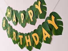 a happy birthday banner made out of green leaves