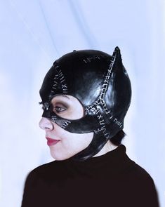 a woman wearing a black leather mask with spikes on it's face and nose