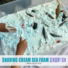 someone is shaving cream sea foam on a sheet of white paper with blue and red sprinkles