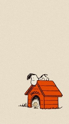 a dog house with snoopy on the roof and a cat in it's bed